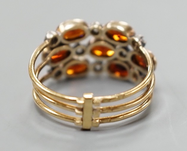 A late Victorian yellow metal, garnet and diamond chip cluster set triple shank ring, size M, gross weight 3.6 grams.